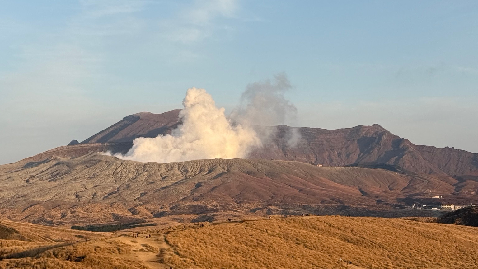 Golden grassland and volcanic mountains in Aso
