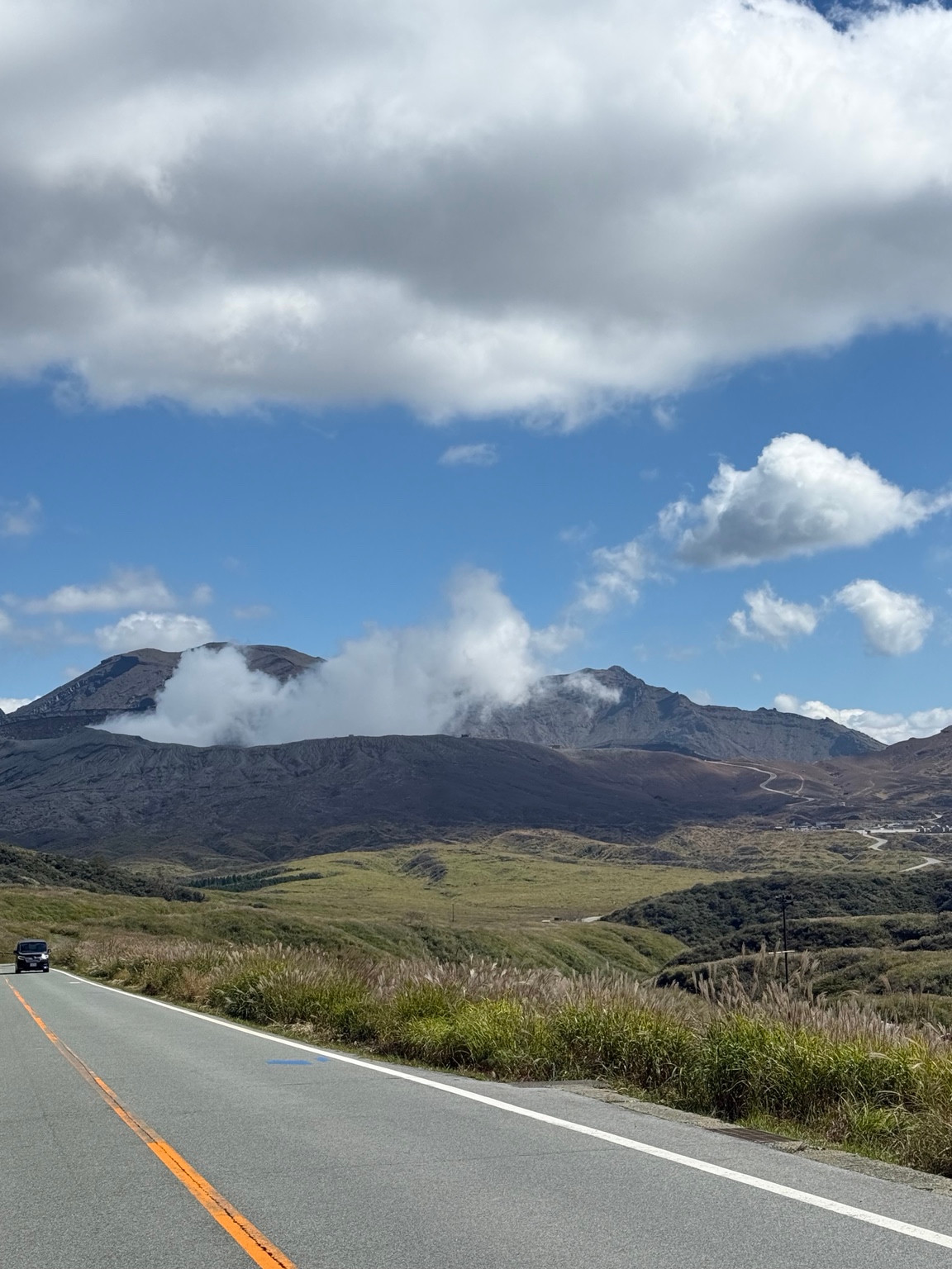 Volcanic mountains and a winding road in Aso